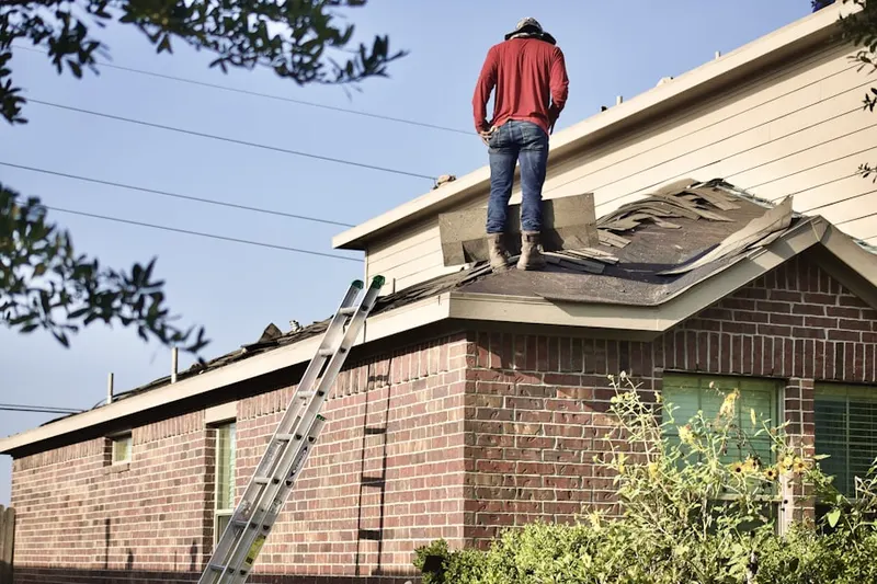 Professional roofer working on a residential roof in Shawnee